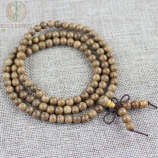 Bracelet mala bois de wengé 108 perles 6 mm enroulé trois tours sur fond lin nœud bordeaux