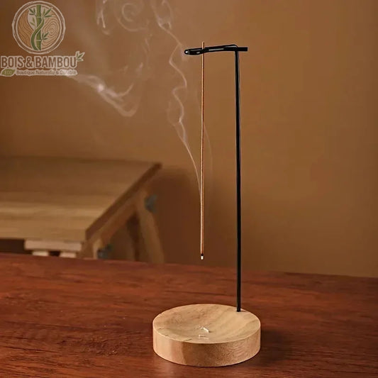 Brûleur d'encens en bois suspendu, base claire et tige noire, fumée qui s'élève