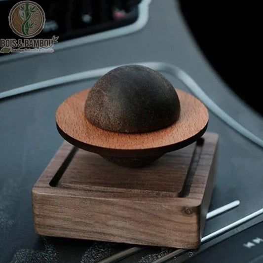 Diffuseur passif bois sculpté Jupiter posé sur tableau de bord de voiture, grain noyer visible