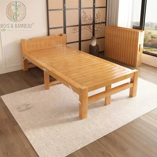 Lit en Bambou Massif Classique 80x190x35. Lit simple pliant en bambou naturel verni disposé sur un tapis clair, montrant sa structure robuste et une version repliée à l'arrière dans une chambre épurée.
