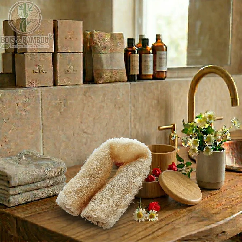 Luffa Entière Naturelle fibreuse posée sur un meuble en bois. Décor de salle de bain rustique avec fleurs, serviettes, boîtes et robinetterie dorée pour une ambiance spa naturelle.