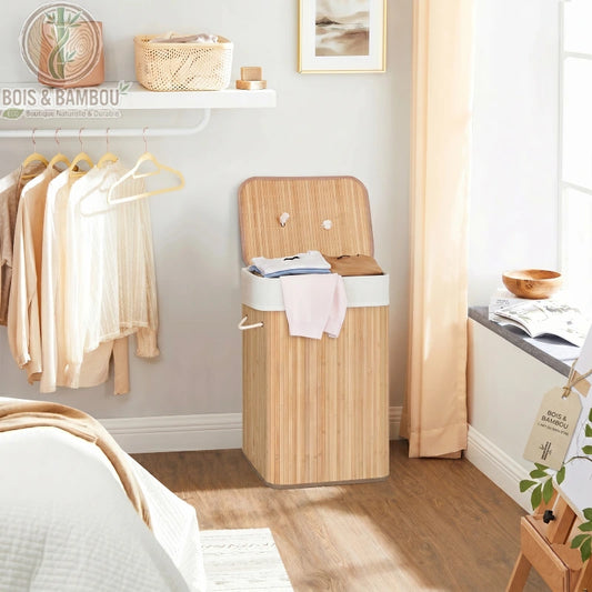 Panier à Linge en Bambou Claire rectangulaire avec couvercle ouvert, rempli de vêtements. Structure en lattes de bambou clair avec doublure en tissu blanc.