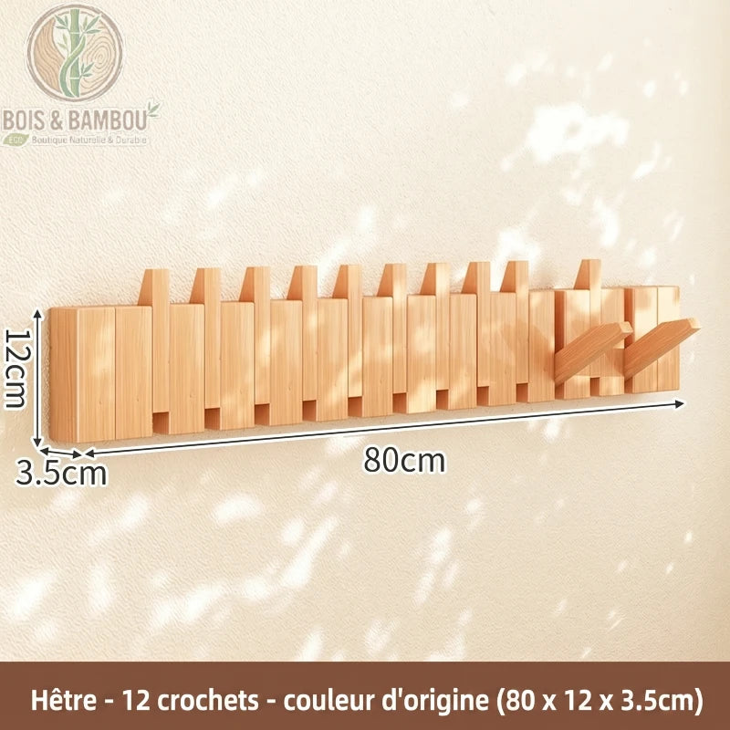 Porte Manteau Piano hetre claire 12 crochets. Un porte-manteau mural de 80 cm en bois de hêtre naturel avec 12 crochets rabattables, affichant ses dimensions précises sur un mur ensoleillé.