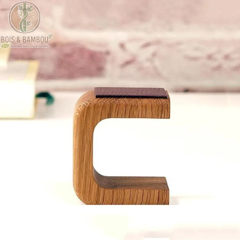 Support de montre en bois massif forme C vue de côté, coussin bordeaux supérieur, fond rose