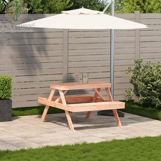 Table de Pique nique en Douglas situation. Mise en situation d'une table de pique-nique en bois de douglas rosé sur une terrasse, abritée par un grand parasol blanc devant une clôture.