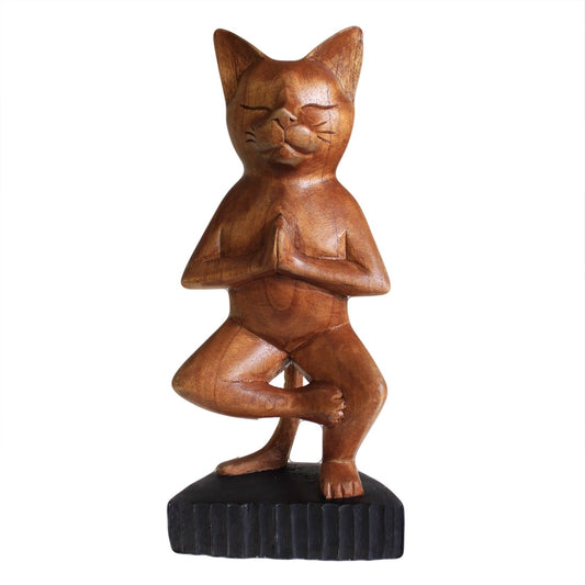 Chat en bois sculpté marron, équilibre sur une patte, fond blanc, vue de face.