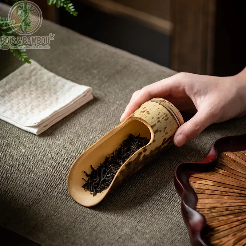 Cuillere a the bambou naturel mouchete tenu en main feuilles the noir plateau rotin fonce - Bois et Bambou Eco
