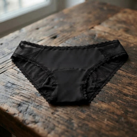 Culotte menstruelle en bambou noire avec dentelle, posée à plat