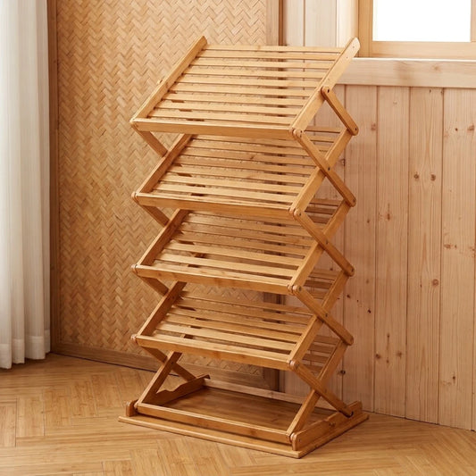 Étagère à chaussures pliable en bambou, structure en X à niveaux inclinés, posée contre un mur