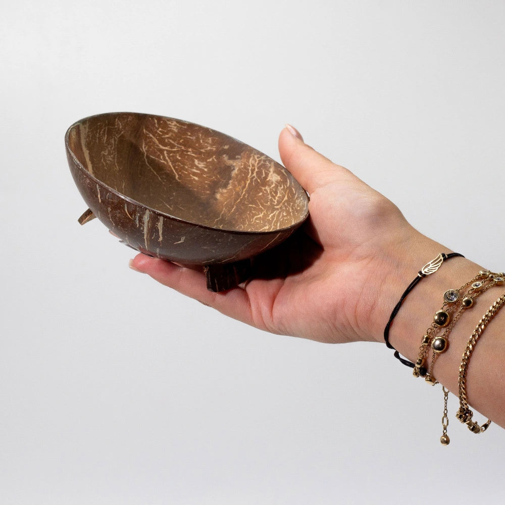 Porte-savon en noix de coco tenu dans une main, format compact
