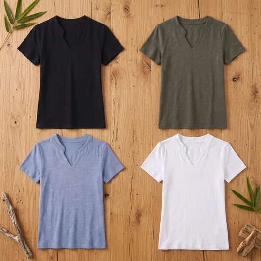 T-shirts femme col V en coton et fibre de bambou présentés à plat en noir, kaki, bleu et blanc sur fond bois naturel