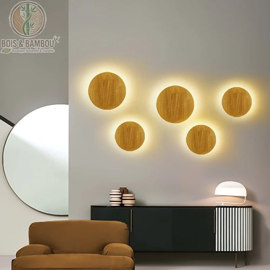 Applique Murale Circulaire en Bois, une installation décorative composée de plusieurs disques en bois de différentes tailles rétroéclairés, créant une ambiance lumineuse artistique et chaleureuse sur un mur de salon contemporain.