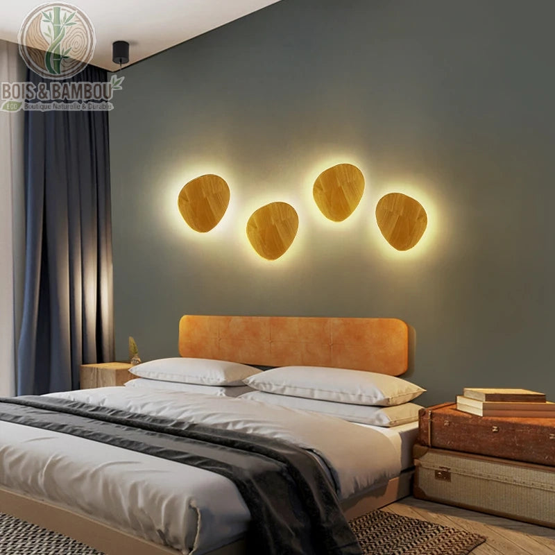 Composition de 4 appliques murales bois LED ovales au-dessus d'une tête de lit, chambre nordique