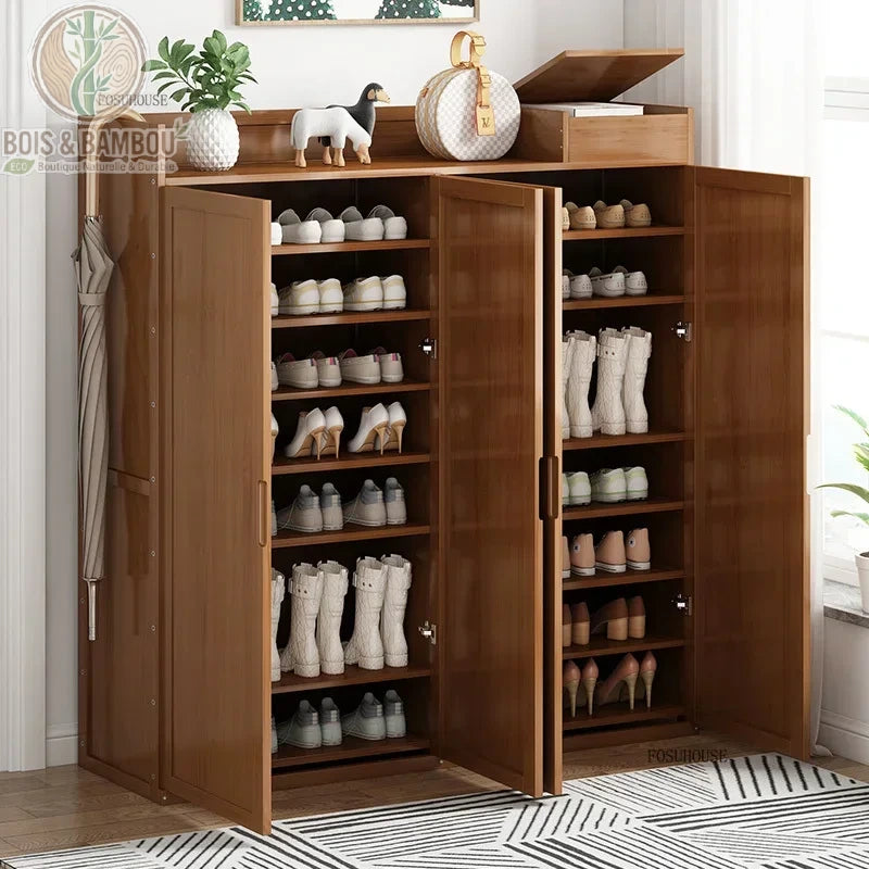 Armoire à chaussures en bambou japonais. Un grand meuble en bois brun à trois portes ouvertes révélant de nombreuses étagères remplies de chaussures, bottes et talons hauts.