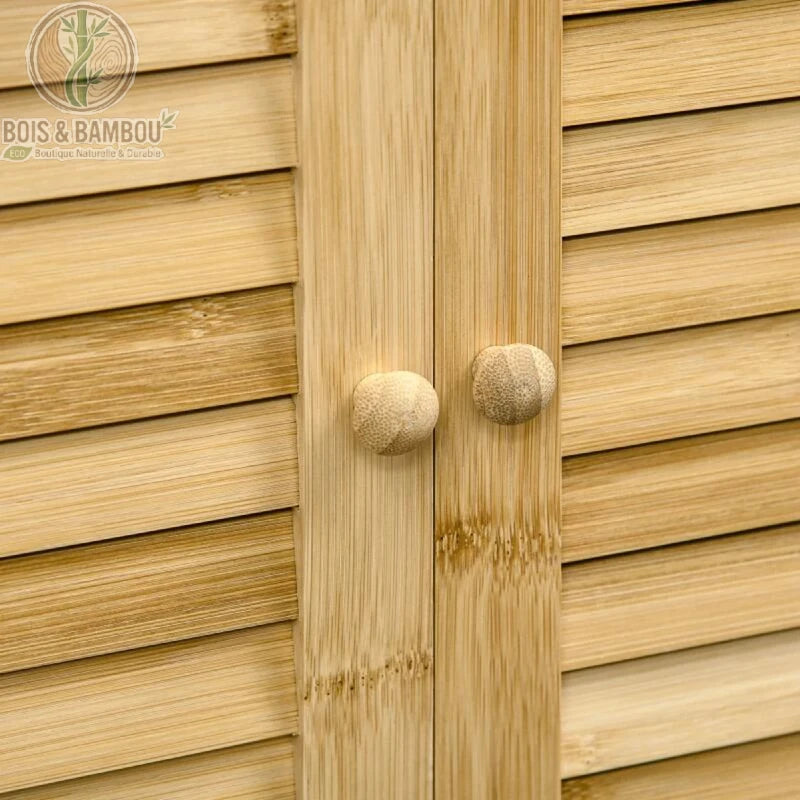 Armoire de salle de bain en bambou details 1. Gros plan sur les portes persiennes en bambou clair de l'armoire, mettant en valeur les deux petits boutons de porte ronds et la texture du bois.