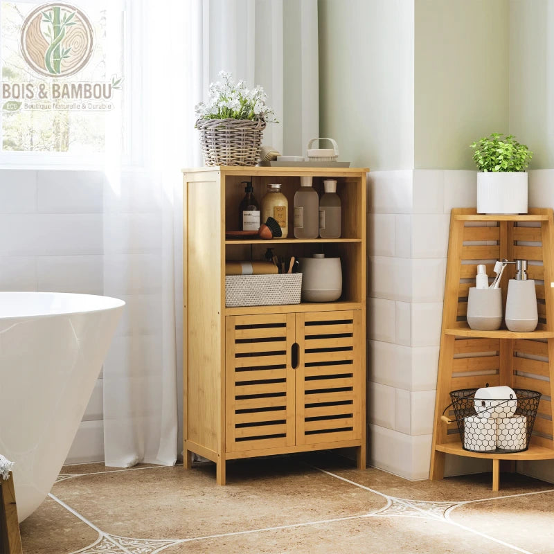 Armoire étagère de salle de bain en bambou. Un meuble en bois clair avec deux niches ouvertes garnies et un placard bas à portes persiennes, placé à côté d'une baignoire blanche.