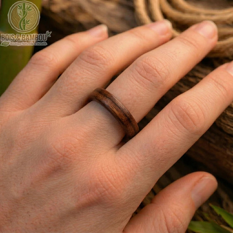 Bague en bois de santal rouge présentant un anneau lisse aux reflets profonds et une texture grainée caractéristique de cette essence précieuse. Ce bijou naturel se distingue par sa teinte pourpre chaleureuse et sa structure artisanale robuste, offrant un design à la fois rustique et élégant.