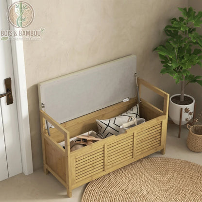 Banc a chaussures en bambou avec coffre de rangement situation 2. Banc en bambou ouvert révélant un grand coffre de rangement intérieur avec coussin, sac et accessoires, sur un tapis en jute.