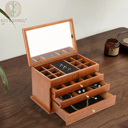 Boîte à bijoux multicouche en bois massif avec miroir intégré et plusieurs tiroirs de rangement. Fabrication artisanale aux finitions soignées pour organiser colliers, bagues et bracelets.