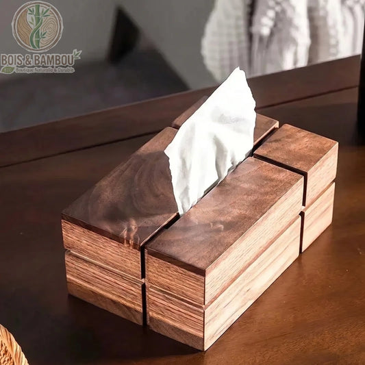 Boîte à mouchoirs en bois nordique. Une boîte rectangulaire au design géométrique en bois sombre poli, laissant dépasser un mouchoir blanc, posée sur une table en bois massif.