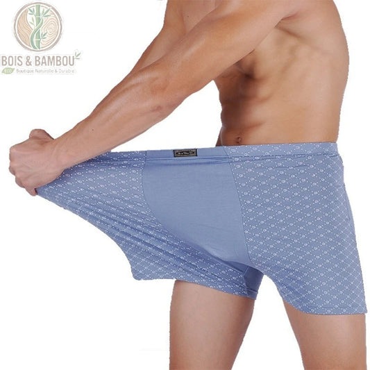 Boxer en fibre de bambou très grande taille. Un homme porte un boxer bleu à motifs discrets, étirant le tissu élastique pour démontrer sa grande extensibilité et son confort.