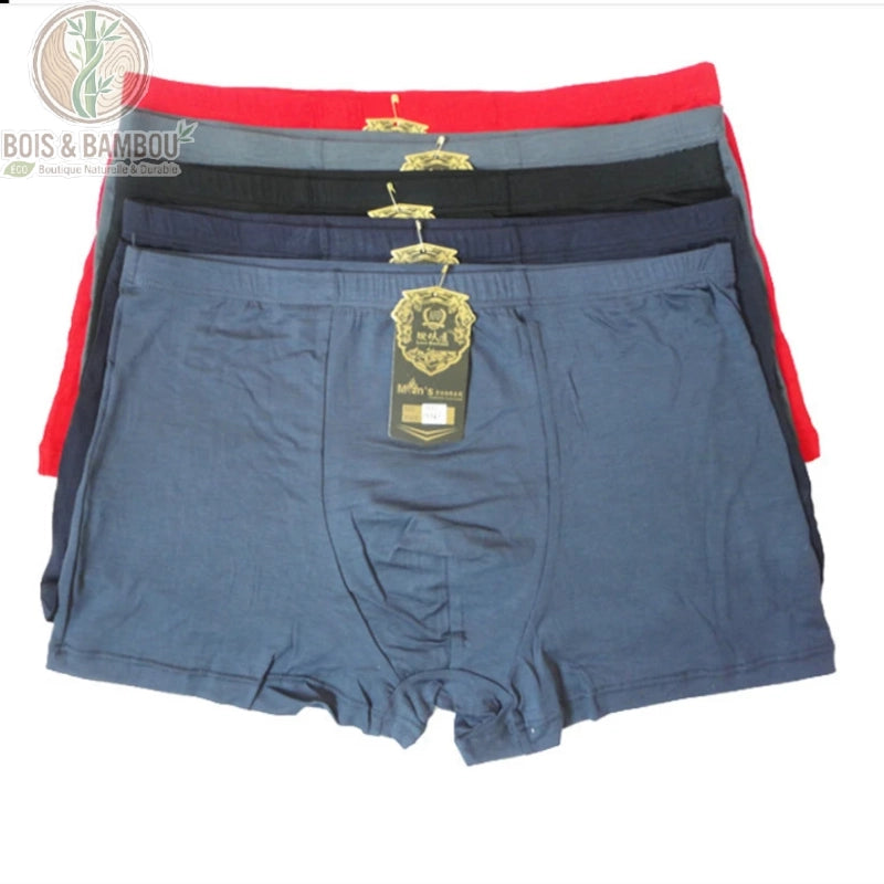 Boxer pour homme en fibre de bambou Noble. Une pile de boxers empilés déclinés en rouge, gris, noir, bleu marine et bleu acier, chacun avec une étiquette dorée de qualité supérieure.