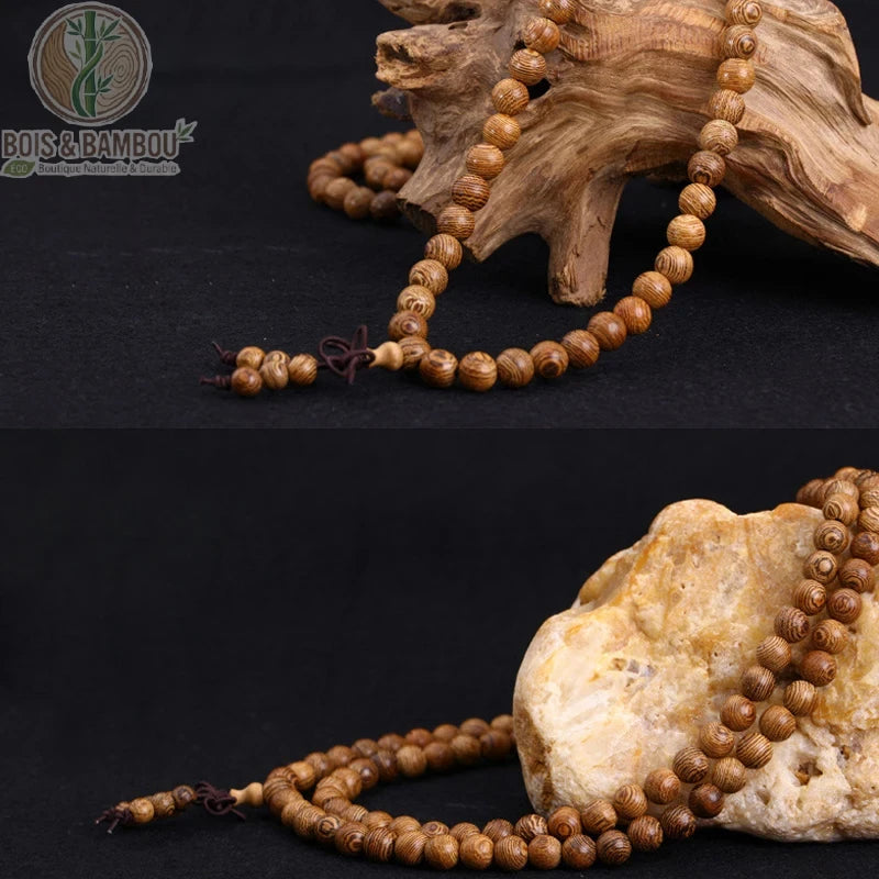 Mala 108 perles bois de wengé déroulé en collier sur fond noir avec racine et pierre naturelles