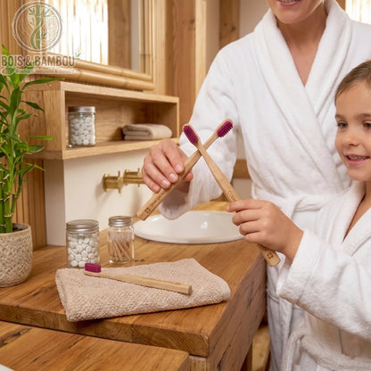 Brosse à Dents en Bois. Une femme et une enfant en peignoir manipulant des brosses à dents en bois aux poils violets dans une salle de bain éco-responsable et boisée.
