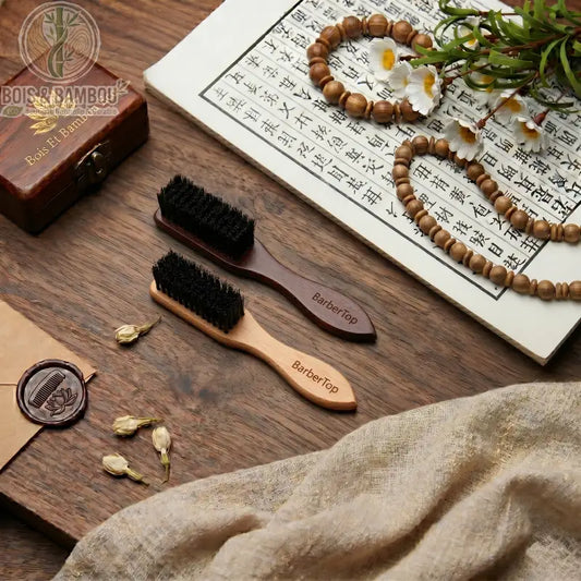Brosse à barbe en bois massif BarberTop, disponible en bois clair et foncé avec poils noirs. Présentée sur table en bois avec décor zen, calligraphie et perles. Soin barbe premium.