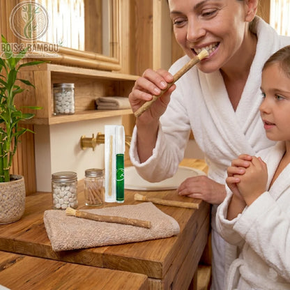 Brosse à dents naturelle Miswak utilisée par une femme en peignoir blanc. Racine de siwak traditionnelle pour un brossage écologique et naturel dans une salle de bain en bois.