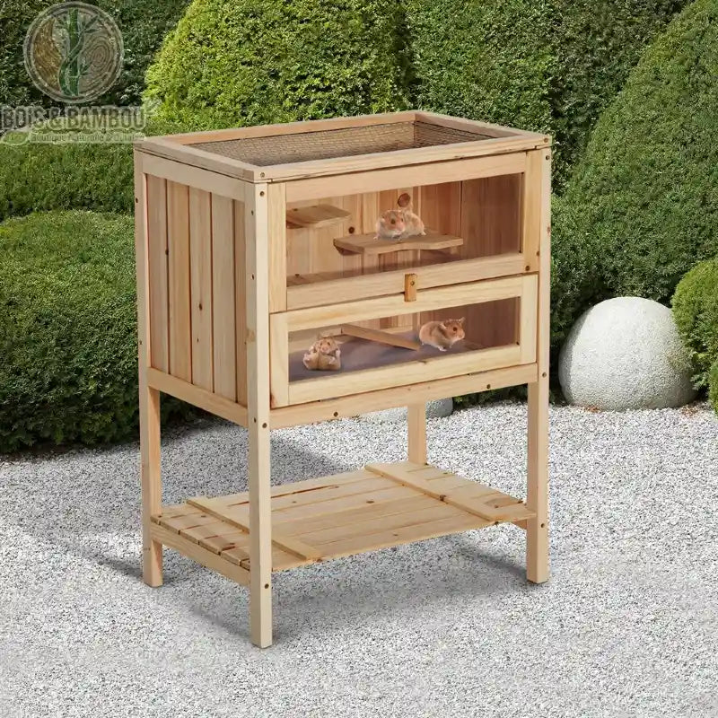 Cage à Hamster en Bois Sur Pieds. Un habitat en bois clair à deux niveaux avec vitres frontales et toit grillagé, accueillant des hamsters et doté d'une étagère de rangement basse.