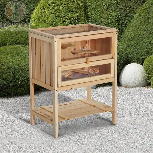 Cage à Hamster en Bois Sur Pieds. Un habitat en bois clair à deux niveaux avec vitres frontales et toit grillagé, accueillant des hamsters et doté d'une étagère de rangement basse.