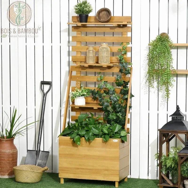Carré potager surélevé en bois. Un bac de culture en bois clair avec un haut treillis muni de petites étagères, décoré de plantes vertes et de lierre devant un mur blanc.