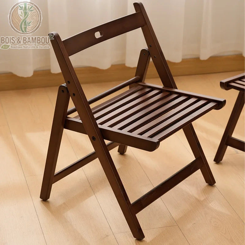 Chaise En Bambou Ilyan Pliante 1. Chaise pliante en bambou teinté marron foncé avec assise à lattes, offrant un design élégant et compact pour un gain de place optimal dans un intérieur moderne.