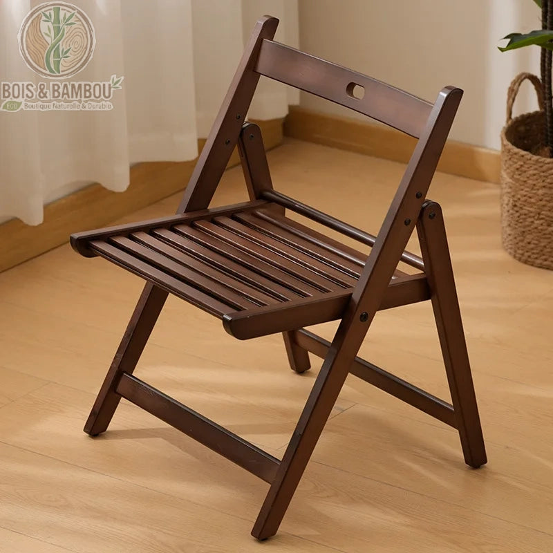 Chaise En Bambou Ilyan Pliante 2. Chaise pliante artisanale en bambou teinté brun foncé, dotée d'une assise à lattes et d'un dossier ergonomique avec poignée, idéale pour un intérieur naturel.