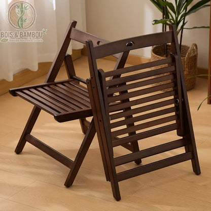 Chaise Pliante Ilyan. Deux chaises pliantes en bambou de couleur marron foncé, l'une ouverte et l'autre repliée, présentant un design à lattes élégant sur un sol en bois clair.