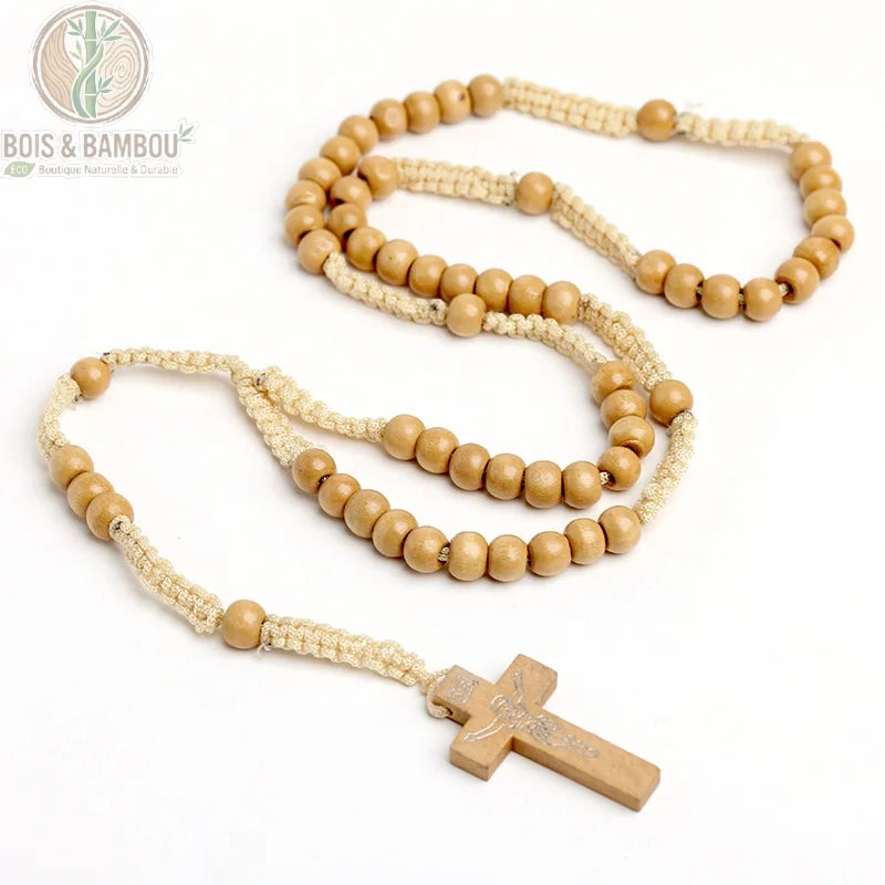 chapelet catholique complet déployé sur fond blanc, perles rondes en bois brun clair enfilées sur cordelette beige tressée, croix en bois sculptée avec Christ en pendentif.