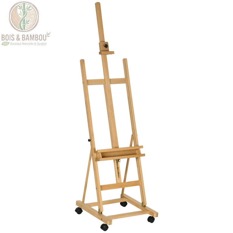 Chevalet d'Artiste en Hêtre, un support robuste et réglable en bois clair monté sur quatre roulettes, conçu pour maintenir des toiles de grand format dans un atelier ou une galerie.