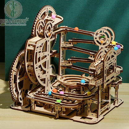 Circuit à billes Marble Run en bois. Une structure complexe à plusieurs niveaux avec engrenages et rails sinueux, animée par des billes colorées, le tout en bois découpé avec précision.