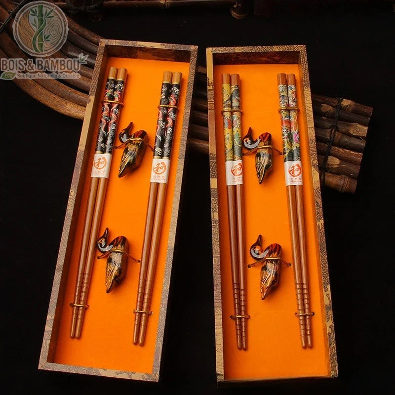 Coffret de baguettes en bambou peint. Deux coffrets luxueux à fond orange contenant des paires de baguettes décorées et des repose-baguettes en forme d'oiseaux sculptés.