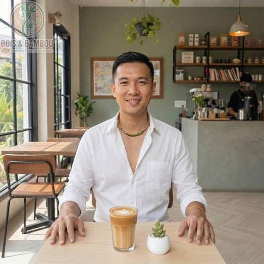 Collier en bois naturel pour homme avec perles colorées, porté par un client souriant dans un café devant un latte.