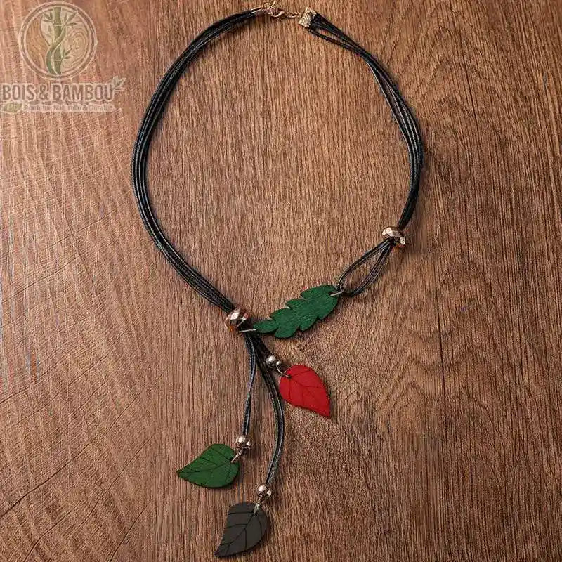 collier pendentif feuilles en bois coloris vert et noir trois feuilles sculptées cordon multibrin fond bois