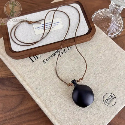 collier long bois sculpté modèle 2 pendentif vase arrondi bois noir mat cordon brun fin réglable