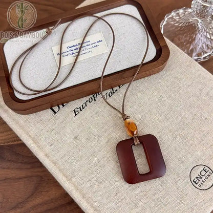 collier long bois sculpté modèle 4 pendentif carré arrondi évidé brun-rouge perle ambre cordon brun