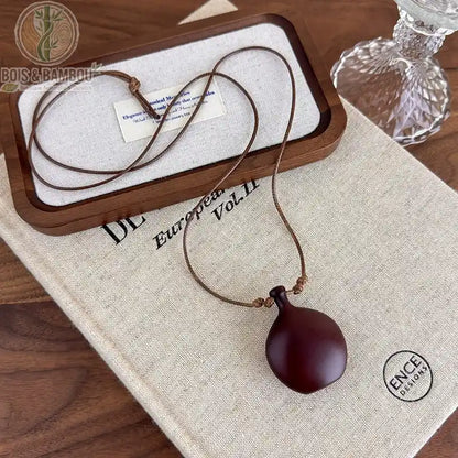 collier long bois sculpté modèle 6 pendentif vase arrondi brun-bordeaux mat cordon brun fin réglable