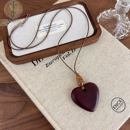 collier long bois sculpté modèle 7 pendentif cœur plein brun-bordeaux perle ambre cordon brun réglable