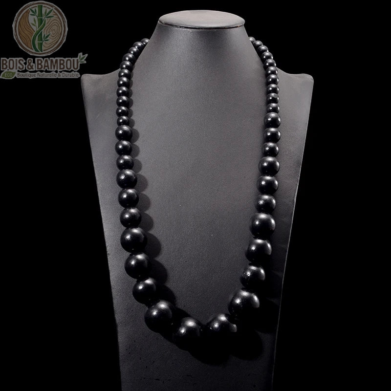 collier plastron grosses perles bois rondes coloris noir mat sur buste fond sombre