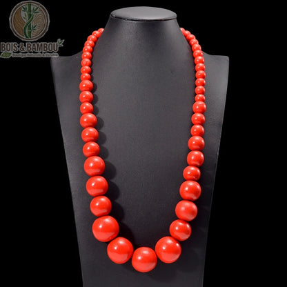 collier plastron grosses perles bois rondes coloris rouge orange sur buste fond sombre