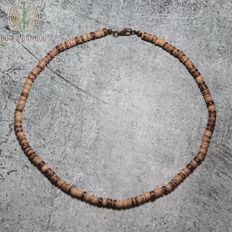 collier ras du cou perles disques bois wengé bicolore beige et brun sur fond béton