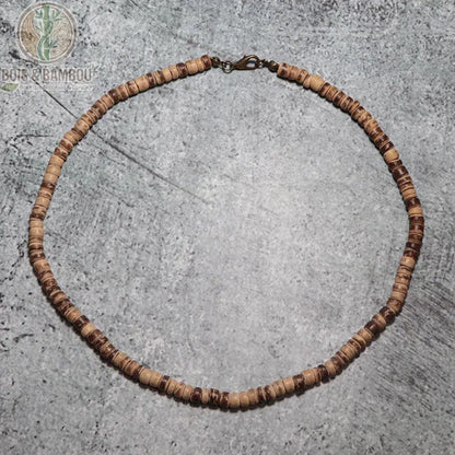 collier ras du cou perles disques bois wengé bicolore beige et brun sur fond béton